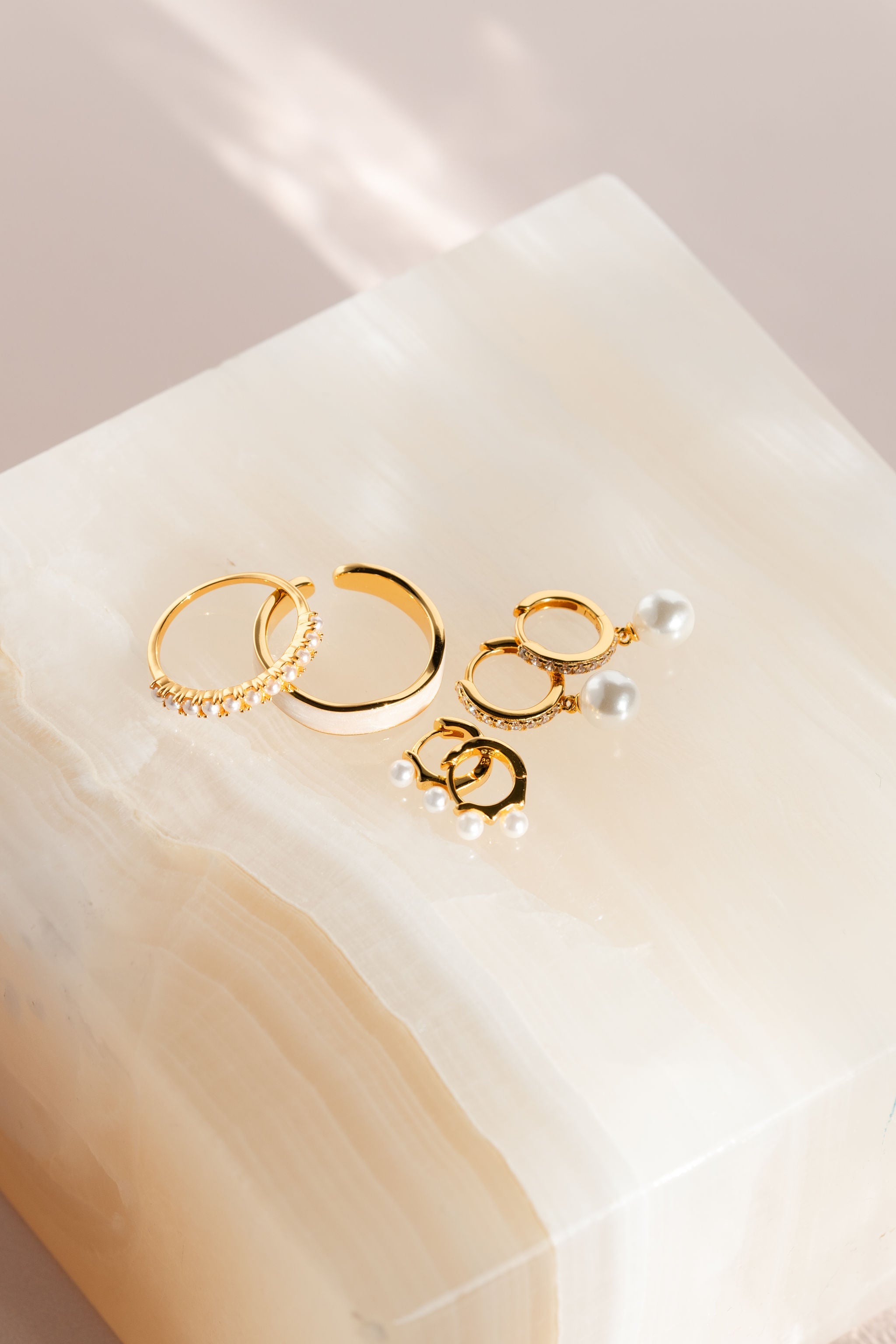 Two pairs of 18k Gold Vermeil earrings with pearl details, and two 18k gold rinds with pearls details from Pink Cove. 