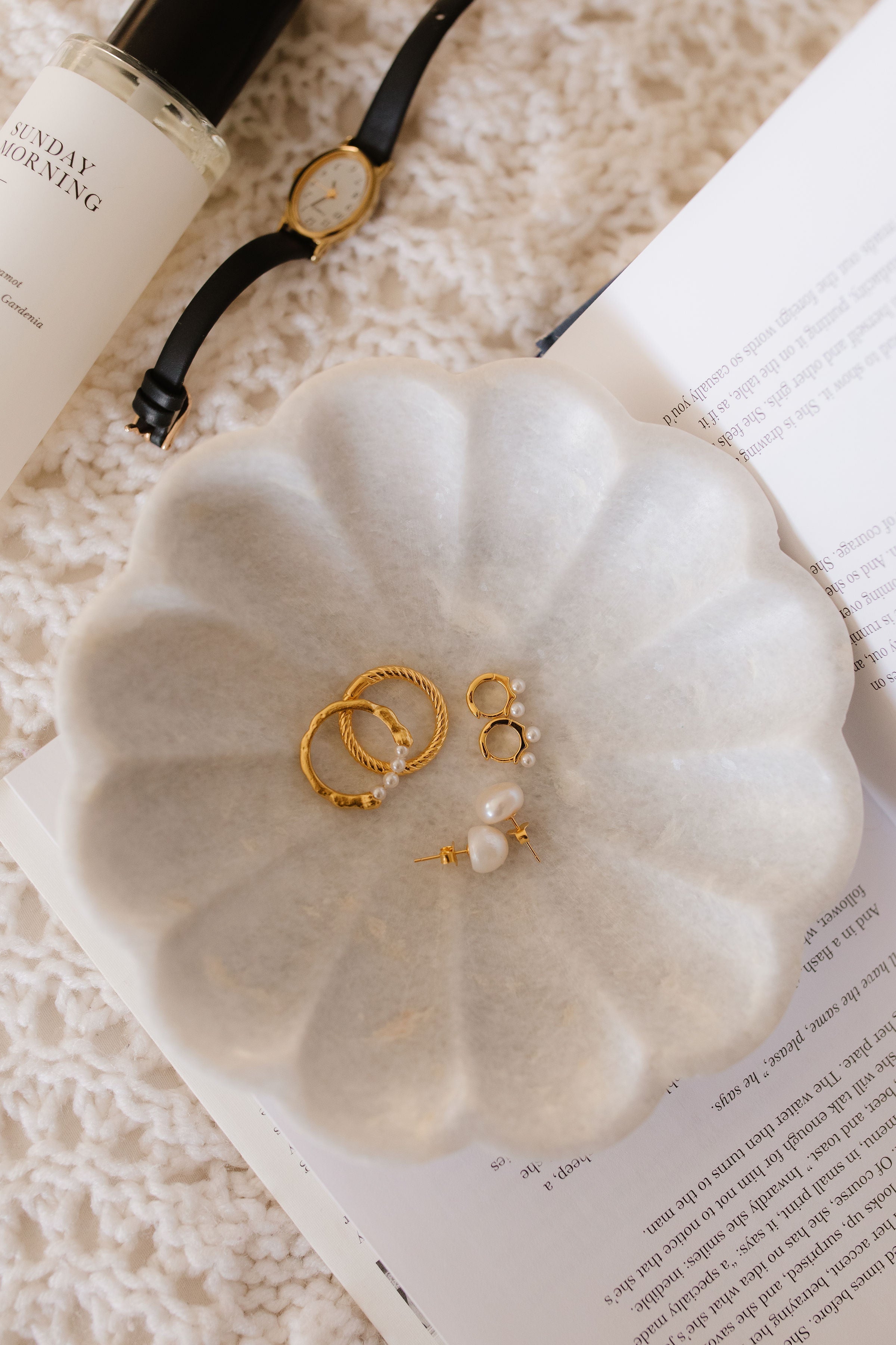 A white dish modeling three pairs of beautiful 18k gold vermeil and pearl earrings from Pink Cove.